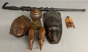 Collection of carved wooden masks, rhino figures, a walking stick and a wooden figure of a man