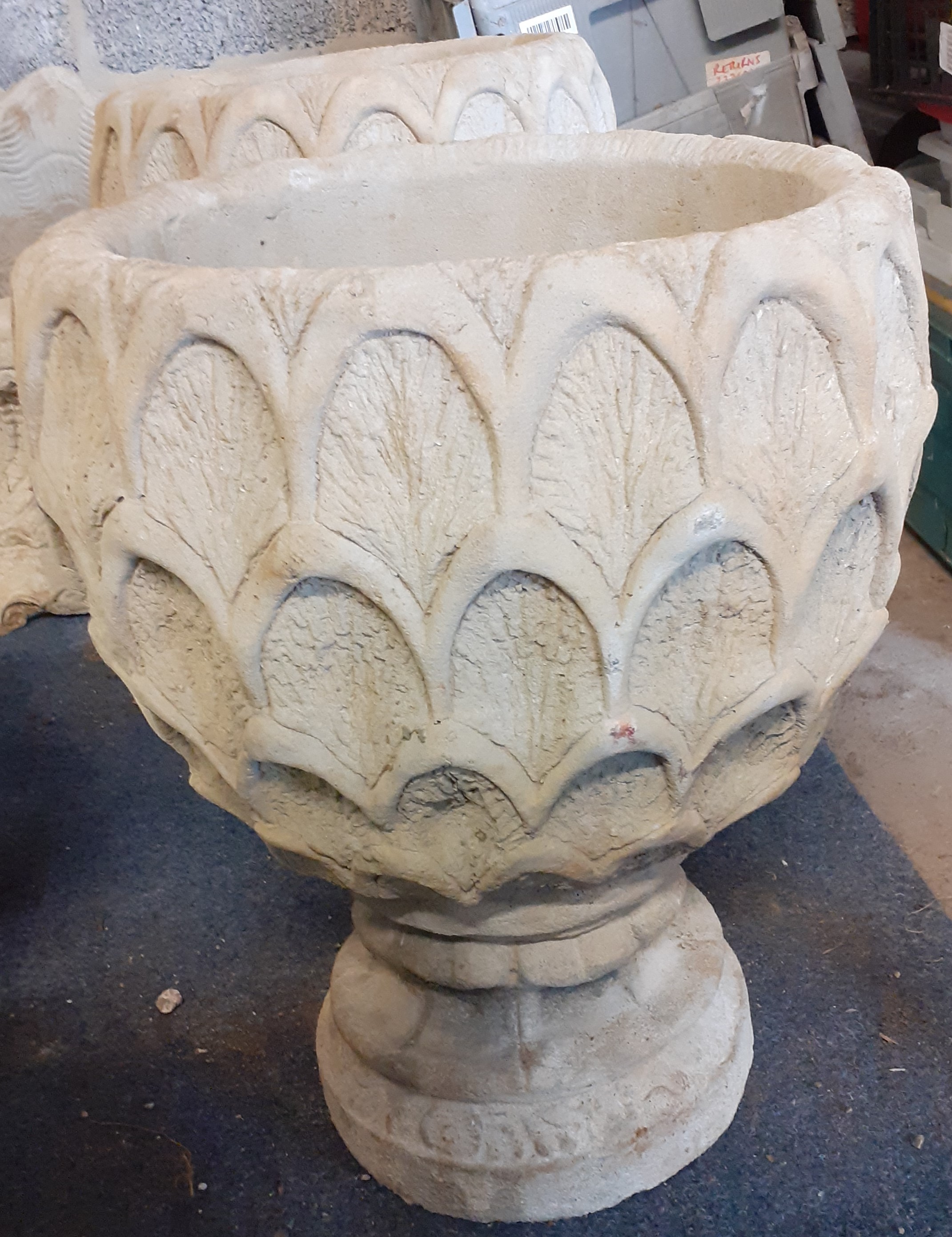 Pair of concrete pineapple urns on circular base