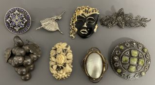 Eight brooches including mother of pearl, 1980's mask brooch, 19th century bone, silver
