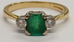 18ct gold emerald (approx. 1.05ct) and two stone diamond ring (total 0.30ct), size T, 4.30g