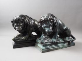 A pair of patinated brass lion doorstops with wild boar, 8" high