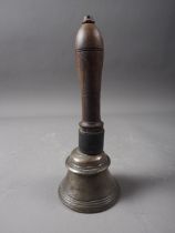 An early 19th century Indian bell metal hand bell with turned hardwood handle, 7 1/2" high