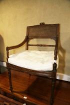 A late 19th century polished as walnut Louis XVI design open armchair with cane seat and back, on