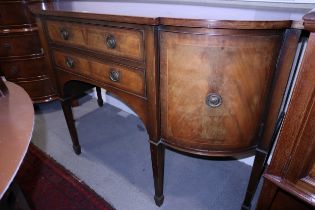 An Edwardian mahogany break bowfront sideboard, fitted two central drawers and flanked cupboards, on