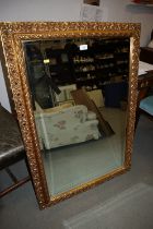 A bevelled plate rectangular wall mirror, in ornate gilt frame, plate 36" x 24"