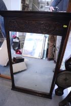 A carved oak wall mirror with Tudor rose decoration, 36" x 23" overall