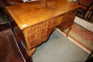 A walnut and feather banded lowboy, fitted seven drawers, on carved cabriole supports, 43" wide x