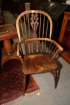An ash and elm Windsor armchair with panel seat and crinoline stretcher