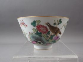 A Chinese porcelain bowl with bird, flower and insects in a landscape decoration, four-character