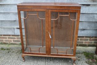 A walnut display cabinet enclosed lattice glazed doors, on cabriole supports, 40" wide x 12" deep