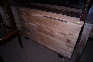 A modern oak sideboard fitted one cupboard and three drawers, on metal supports, 47" wide x 20" deep