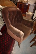 An early 20th century tub chair, button upholstered in a chocolate velour, on turned supports