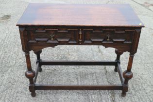 An oak side table of 17th century design, fitted two drawers, on turned and stretchered supports,