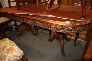 A French style walnut and banded oval dining table with carved frieze, on two bulbous tripod splay