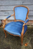 A polished as walnut open armchair of Louis XVI design, upholstered in a blue velour, on cabriole
