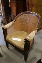 A 19th century mahogany tub chair with caned seat and back, on reeded supports (seat damaged)