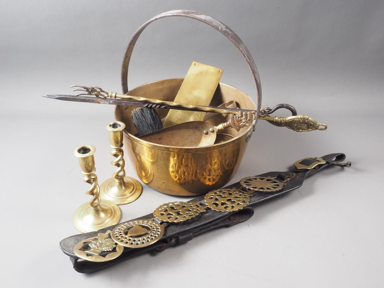 A brass preserve pan, a leather chest strap with five horse brasses and other brassware