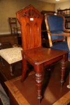 A late Victorian carved mahogany hall chair, on turned supports