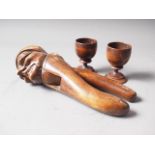 A 19th century carved wood nutcrack, 8" long, and a pair of treen egg cups, 2 1/2" high
