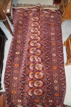 A Bokhara rug of traditional design with thirty-three guls on a plum ground and multi-bordered in