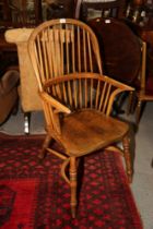 A Windsor spindle back elbow chair with beech panel seat, on turned crinoline stretchered supports