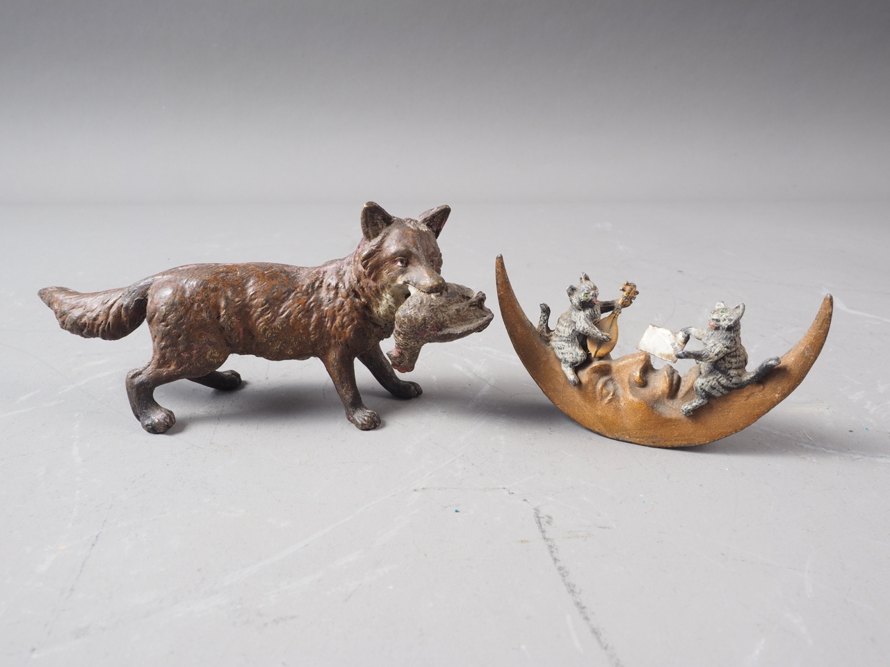 A cold painted bronze of a fox holding a chicken, 5" long, and a cold painted model of two cats on