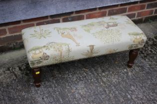 A modern rectangular footstool, upholstered in an African themed fabric, and a 1960s nest of