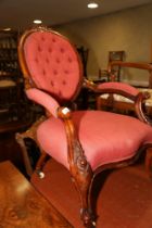 A Victorian carved mahogany showframe spoon back chair, upholstered in a crimson fabric, on carved