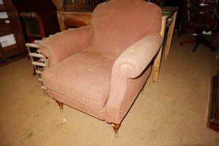 A modern deep seat armchair, upholstered in a brown chequered fabric, on turned and castored