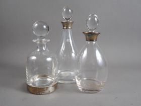 Two glass decanters with silver collars and a Links of London glass decanter with silver base