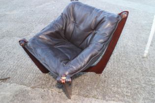 A 1970s design Danish leather low seat armchair, on 'X' frame support