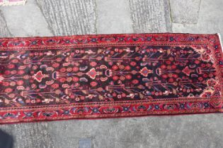 A Persian Nahavan wool runner of traditional design on a deep ground, 126" x 40" approx