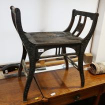 A Liberty style ebonised carved hardwood stool