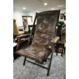 An early 20th century leather folding adjustable open armchair