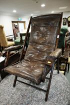 An early 20th century leather folding adjustable open armchair