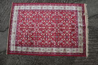 A Kashmir carpet with floral motifs on a red ground with gold border, 67" x 47" approx