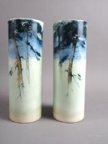 A pair of Royal Worcester "Sabrina Porcelain" cylinder vases, decorated pine trees at night,