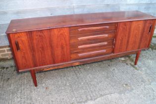 A 1960s Danish rosewood sideboard, fitted for centre drawers and flanking cupboards enclosed sliding