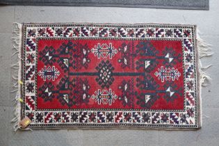 A Hamadan rug with central hooked gul on a red ground, 46" x 27" approx