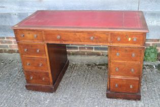 A walnut double pedestal desk with tooled red leather top, fitted nine drawers, on block base, 48"