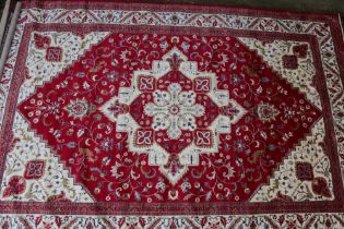 A Kashmir full pile carpet with floral design on a red ground, 118" x 78" approx