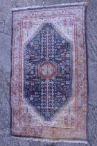 A Persian rug with tree design on a blue ground and floral banded in shades of pink, red, blue,