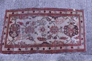 A Caucasian tribal rug in shades of fawn and brown (very worn), 35" x 66" approx, and a tribal rug