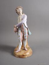 A German porcelain figure/spill vase, formed as a young man holding a jug, 11" high