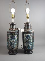 A pair of early 20th century cloisonne vases with floral panels on a dark blue ground, now converted