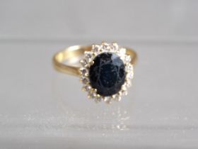 A yellow metal, sapphire and diamond cluster ring, size T/U, 5.8g
