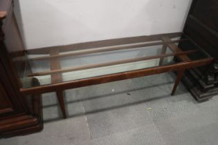 A 1960s teak and smoked glass top coffee table, on turned supports, 54" wide x 16 1/2" deep x 17"