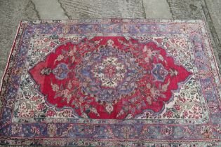 A Persian Nadjaffabad carpet of traditional design on a red ground, 138" x 98" approx