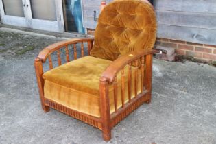 A Liberty type oak frame fireside recliner armchair with loose seat and back cushions, in a snuff