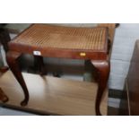 A 1930s carved walnut dressing stool with cane seat, on cabriole supports, 24" wide x 16" deep x 20"